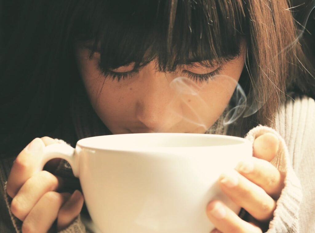 pexels-photo-460257 Woman savoring the aroma of a hot coffee cup in a cozy setting.